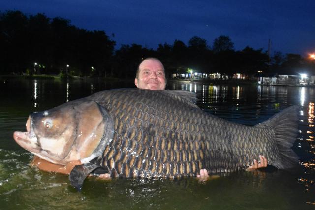 Vinny Huermann beside Big Girl, the giant Siamese carp caught at Palm Tree Lagoon in Thailand.